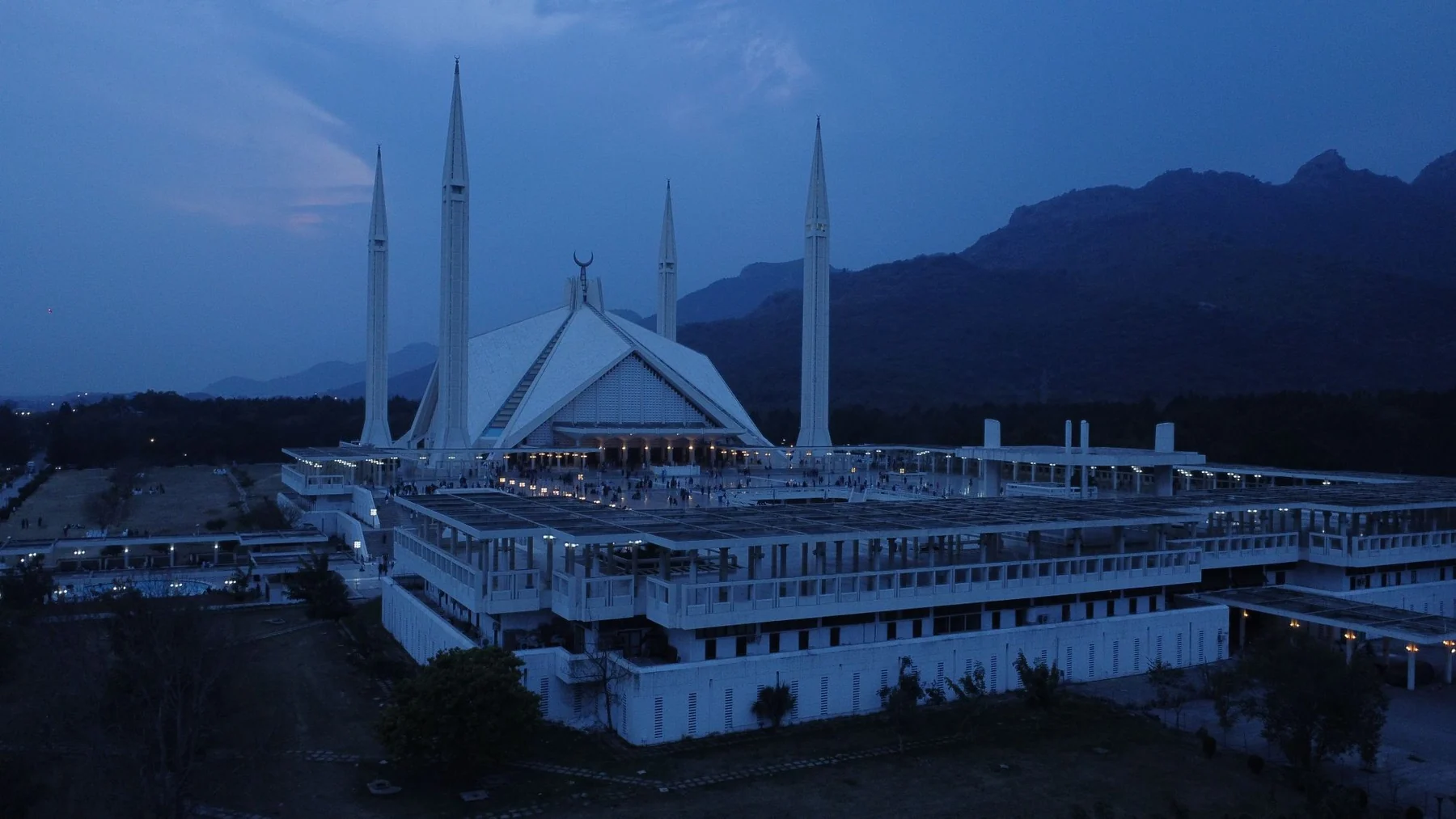 Aerial view of Faisal Mosque in Islamabad during evening twilight, showcasing its iconic minarets.