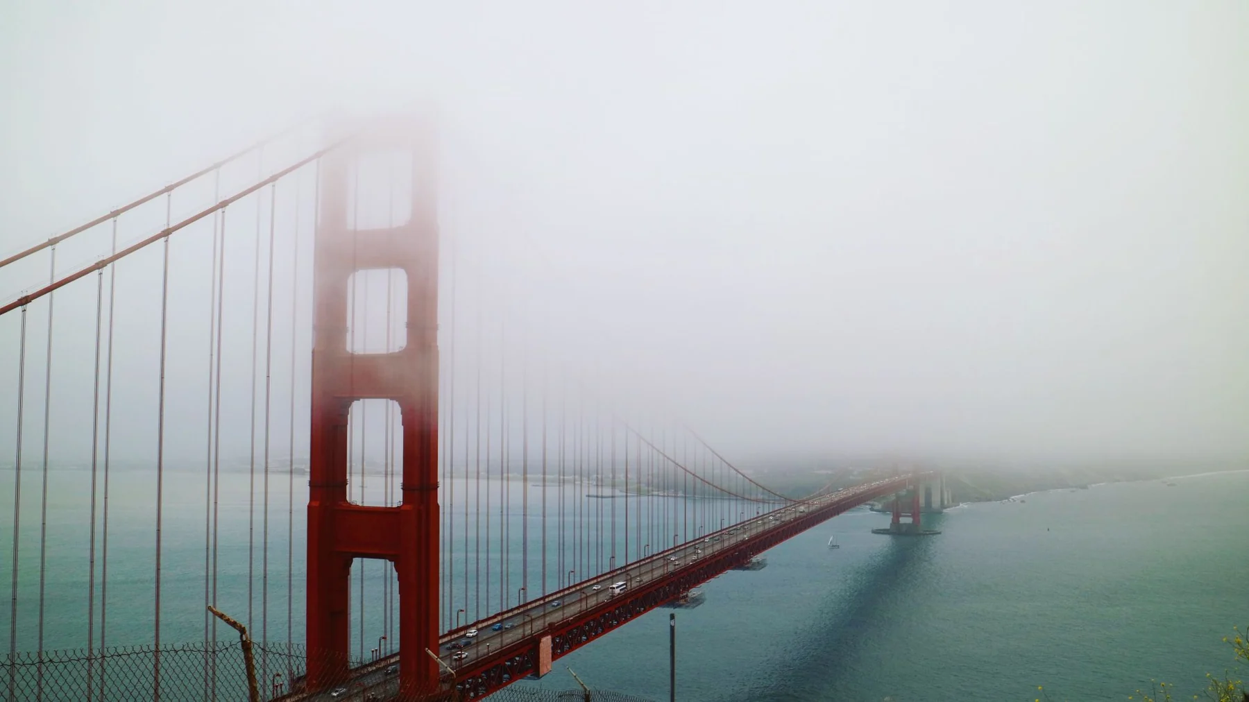 Ethereal view of San Francisco's Golden Gate Bridge shrouded in fog.