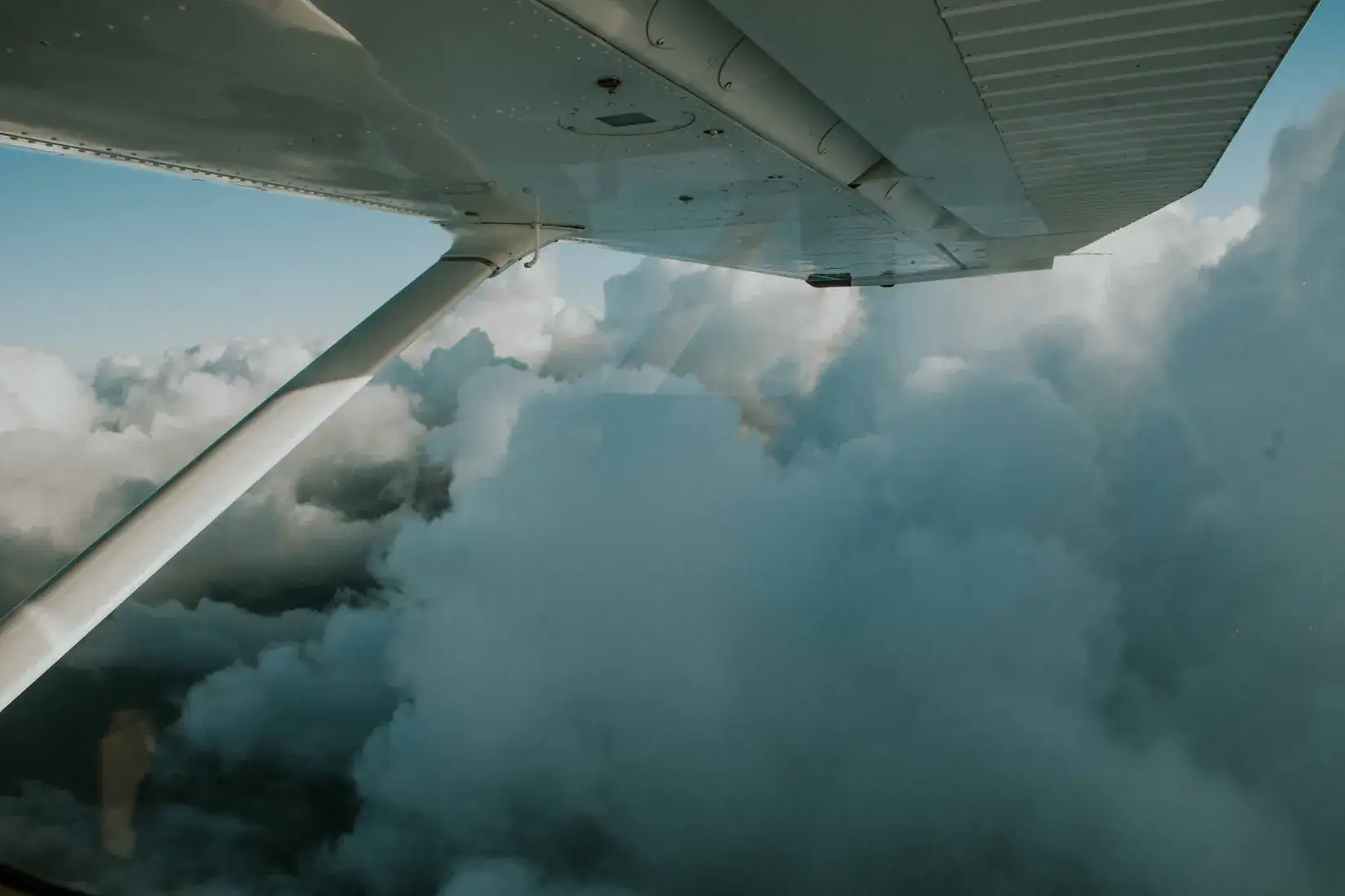 Airplane wing over clouds